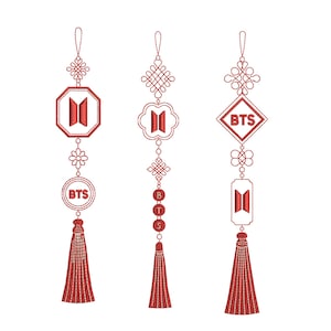 May include: Three red embroidered ornaments with the letters "BTS" and decorative elements. Each ornament has a different shape, including a circle, octagon, and diamond, and is finished with a tassel.