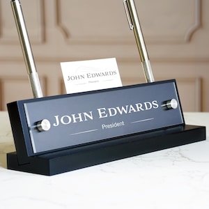Placa de identificação de mesa personalizada com caneta e porta-cartão de visita. Feito exclusivamente pela Garo Signs. Tamanho 10" x 2,5"