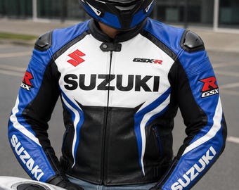 Puede incluir: Una chaqueta de moto de cuero azul, blanco y negro con el logotipo de Suzuki y el texto GSX-R en el pecho y las mangas. La chaqueta incluye un cuello mao con cierre de botón a presión, hombreras negras y una cremallera frontal completa.