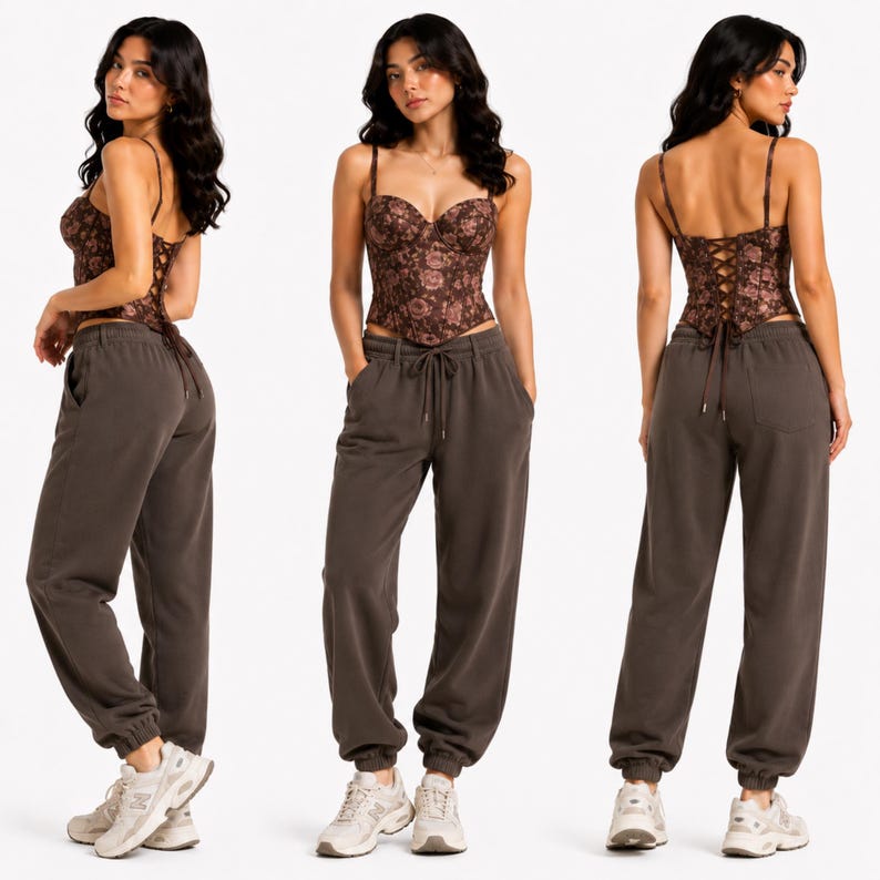 May include: A brown floral print corset top with spaghetti straps and a lace-up back. Paired with dark brown sweatpants with a drawstring waist and elastic cuffs. The model is wearing white sneakers.