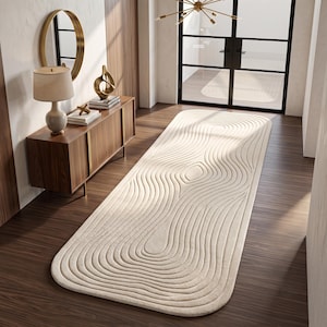 May include: A long, rectangular runner rug in a solid cream color featuring a raised, textured pattern of concentric, flowing, organic lines that mimic the appearance of wood grain or topographical contours across the entire surface.