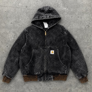 Puede incluir: Una chaqueta con capucha en gris y negro con efecto lavado al ácido, cierre de cremallera frontal, dos bolsillos delanteros y puños y dobladillo acanalados en color marrón. Incluye una etiqueta rectangular de la marca Carhartt en el bolsillo.