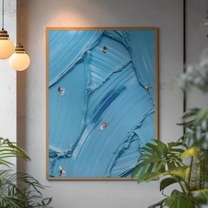 May include: A rectangular wall art piece featuring a thick, textured impasto oil painting in shades of light and medium blue. The artwork depicts several small, stylized figures of surfers riding waves across the textured blue paint surface.
