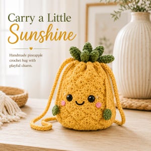 May include: A yellow pineapple-shaped crochet drawstring bag with a green leafy top, black bead eyes, a stitched smile, and pink cheeks. The text reads: Carry a Little Sunshine. Handmade pineapple crochet bag with playful charm.