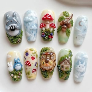 May include: A set of ten sculpted nail art designs featuring whimsical forest and fantasy themes. Designs include mushrooms, acorns, clouds, a house, and characters. The nails showcase a variety of colors and textures, with detailed three-dimensional elements.
