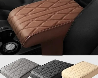 Puede incluir: Se muestra un reposabrazos de coche marrón con costuras de diamante, instalado en un vehículo. Debajo, se muestran tres reposabrazos adicionales en gris, negro y beige. Los reposabrazos están hechos de un material similar al cuero y están diseñados para la comodidad y el estilo.