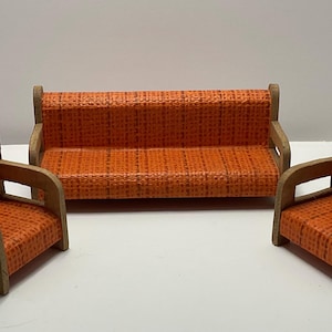 May include: A miniature orange sofa and two armchairs with wooden frames. The furniture set features a woven orange fabric on the seats and backs. The set is designed for a dollhouse or miniature display.