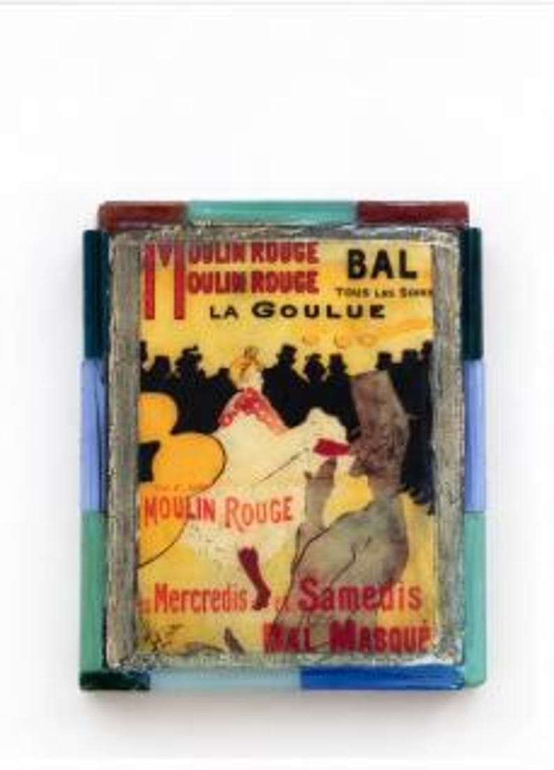 May include: A rectangular decorative plaque featuring a Moulin Rouge La Goulue poster print, framed by a border of multicolored glass tiles in shades of blue, green, and red. The print displays figures in a yellow and black setting.