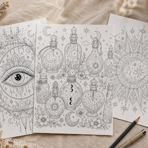May include: Three black and white coloring pages featuring celestial and mystical designs. One page has an eye within a crescent moon, another has potion bottles, and the third has a sun and moon design. A pencil and pen are in the foreground.