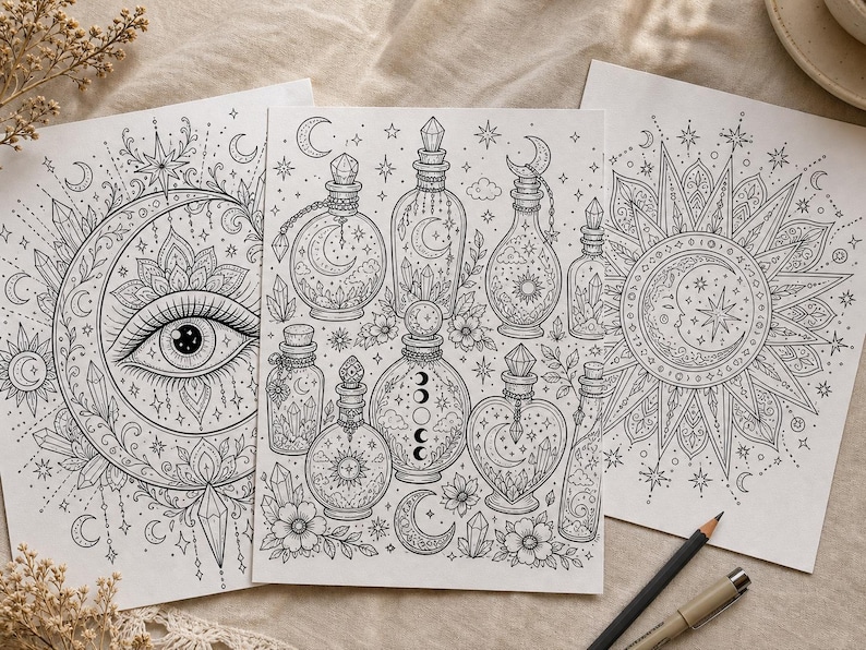 May include: Three black and white coloring pages featuring celestial and mystical designs. One page has an eye within a crescent moon, another has potion bottles, and the third has a sun and moon design. A pencil and pen are in the foreground.