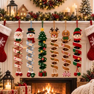 Könnte beinhalten: Sechs hängende Weihnachtsdekorationen aus Häkelarbeit, bestehend aus Weihnachtsmann, Schneemann, Tannenbaum, Rentier, Lebkuchenmann und Elf. Jede Figur ist an einem langen, spiralförmigen, bunten Häkelband mit kleinen festlichen Motiven befestigt.