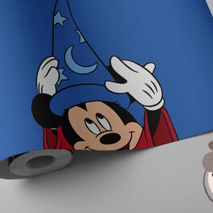 May include: A roll of blue wallpaper featuring a graphic of Mickey Mouse wearing a blue wizard hat with moon and star patterns and a red robe. The wallpaper includes a smoothing tool and a precision knife for application purposes.