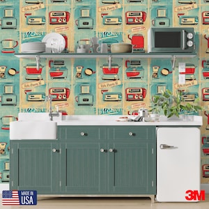 May include: A kitchen scene featuring a white farmhouse sink, sage green cabinets, and a white mini-fridge. A shelf above holds stacked white plates, a tan pot, and a gray microwave. The wall is covered in wallpaper with a retro kitchen appliance pattern.
