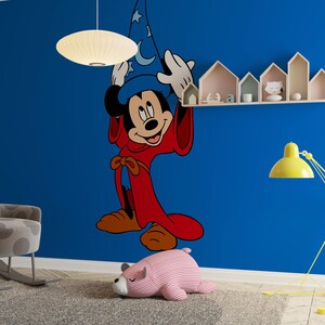 May include: A large wall decal of Mickey Mouse dressed as a sorcerer, featuring a blue hat with white moon and star patterns and a long red robe. The character is depicted with white gloves, standing against a solid blue wall in a room.
