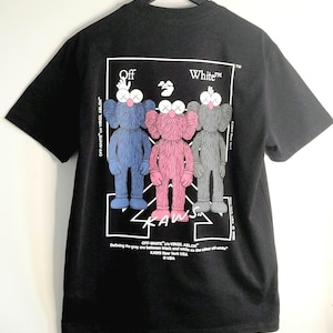 May include: Black t-shirt featuring three cartoon figures in blue, pink, and gray, with the text "OFF-WHITE" and "KAWS" in white. The figures have X-shaped eyes and are standing in a row. The shirt is hanging on a black hanger.
