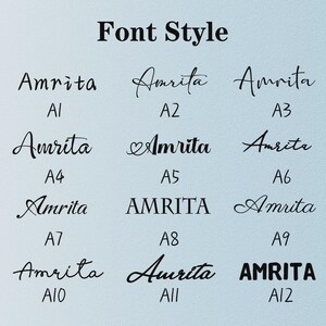 May include: A font style chart displaying twelve variations of the name Amrita in black text on a light blue background. Each option is labeled with an alphanumeric code from A1 to A12, showcasing diverse typographic styles including script, serif, and sans-serif.