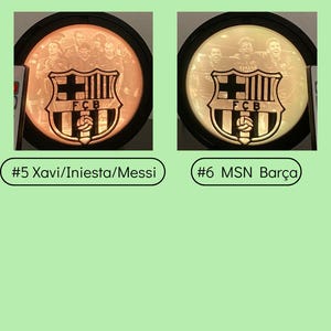 Puede incluir: Dos l&aacute;mparas LED con dise&ntilde;os circulares con el logo del FCB e im&aacute;genes de jugadores. Una l&aacute;mpara est&aacute; etiquetada como "#5 Xavi/Iniesta/Messi", la otra como "#6 MSN Bar&ccedil;a". Las l&aacute;mparas tienen un borde negro y el texto "Led Lamp" y "2Y PRINTS" son visibles.