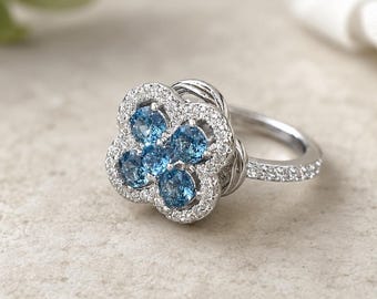 Blauwe ring met sprankelende bloemen, zilverkleurige klaver met accentstenen