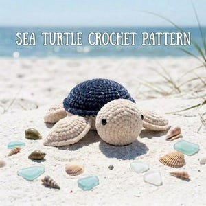 Peut inclure: Une tortue de mer en crochet faite à la main avec une carapace bleu marine foncé, une tête et des nageoires couleur crème clair et des yeux en perles noires. Le texte SEA TURTLE CROCHET PATTERN est écrit en blanc au-dessus de la tortue.