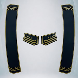 May include: Two long, curved black decals with gold-coloured chevron and dash patterns at the ends, accompanied by two smaller, rectangular black decals featuring matching gold-coloured chevron and dash designs on a plain white background.