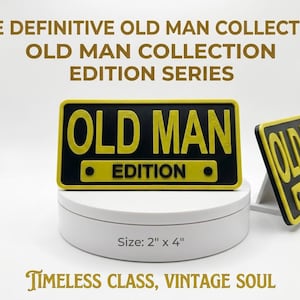 May include: Two rectangular black and yellow plastic signs featuring the text OLD MAN EDITION in raised lettering. The signs measure 5.08 cm by 10.16 cm. One sign is displayed horizontally on a white circular base, while the other stands upright.