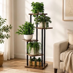May include: A multi-tiered plant stand with five shelves, each holding potted greenery. The stand has a dark brown wooden frame with black metal supports. The plants include various types of green foliage in white and wooden pots.