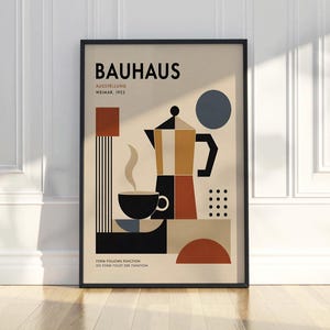 Op de afbeelding: Een ingelijste Bauhaus-tentoonstellingsposter uit Weimar 1923 met geometrische vormen in zwart, beige, roest en blauw. De print toont een gestileerde koffiepot, een dampende kop en de tekst Bauhaus, Ausstellung, Weimar, 1923, Form Follows Function.