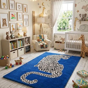 May include: A rectangular area rug featuring a large, white and black spotted leopard graphic centred on a vibrant blue background. The rug has a soft, plush texture and is positioned on a light-coloured wooden floor in a nursery room.