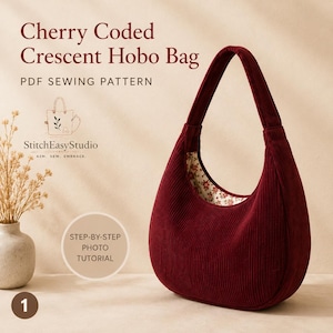 Op de afbeelding: Een bordeauxrode corduroy crescent hobo tas met een bloemenpatroon aan de binnenkant. De tas heeft een lange, gebogen band. De tekst "Cherry Coded Crescent Hobo Bag" en "PDF Sewing Pattern" zijn zichtbaar.