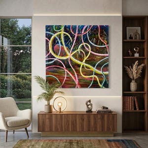 Puede incluir: Pintura abstracta con líneas onduladas en amarillo, rosa y blanco sobre un fondo oscuro. La obra de arte cuelga sobre un mueble de madera con una lámpara y objetos decorativos. Una alfombra y una silla completan el interior moderno.
