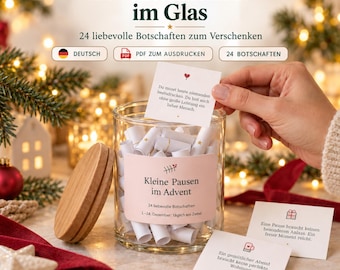May include: A clear glass jar with a wooden lid containing rolled paper notes. The jar features a label with the text 'Kleine Pausen im Advent' and '24 liebevolle Botschaften'. Several small white cards with printed text and icons are displayed alongside the jar.
