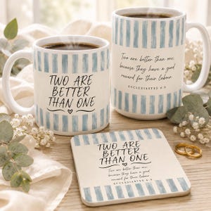 May include: Two ceramic mugs and a square coaster featuring blue and white vertical stripes. One mug displays the text "TWO ARE BETTER THAN ONE" with a heart. The other mug and the coaster feature the full verse "Two are better than one; because they have a good reward for their labour. ECCLESIASTES 4:9".
