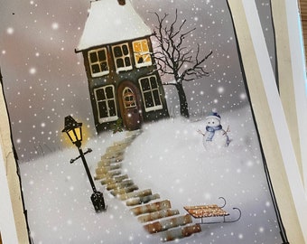 May include: A snowy winter scene with a small house, a snowman, a lamppost, and a sled. The house has a lit window and a snow-covered roof. The snowman is wearing a blue scarf. The lamppost is casting a warm glow on the snow-covered ground.