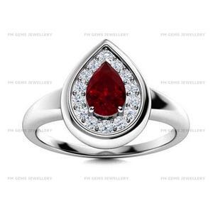 May include: A silver-toned ring featuring a pear-shaped deep red gemstone at the center, surrounded by a halo of small clear stones. The setting is smooth and polished, with the text FM GEMS JEWELLERY repeated across the image background.