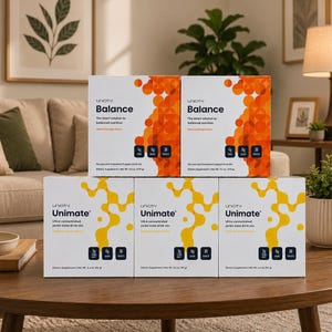 May include: Two white boxes of Unicity Balance dietary supplement with orange circular graphics and three white boxes of Unicity Unimate yerba mate drink mix with yellow abstract graphics, all featuring black text and nutritional information labels.