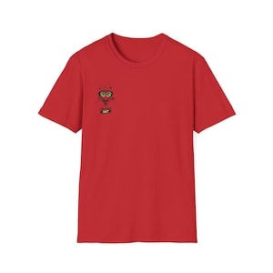 May include: A red t-shirt featuring a cartoon cat wearing goggles and a hat. The cat illustration is in black, green, and yellow. The text "RAVER CAT" is below the cat image.