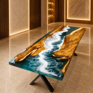 May include: A rectangular dining table featuring a natural live-edge wood slab with a central river design made of blue and white resin. The resin mimics flowing water with white foam details. The table has black metal X-shaped legs. Text reads StonecraftsIndia.