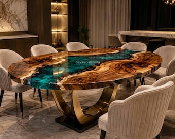 Op de afbeelding: Een ovale eettafel met een houten blad met natuurlijke randen en een centrale inleg van doorschijnende turquoise hars. De tafel rust op een gebogen goudkleurig metalen onderstel en is omringd door beige gestoffeerde stoelen met zwarte poten.