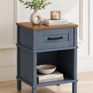 May include: A blue wooden nightstand with a drawer and open shelf. The top is a natural wood color. It has a vase with greenery, a candle, a bowl, and books that read "LIVE BEAUTIFULLY" and "THIS IS HOME" and "down to earth".