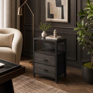 May include: A dark gray nightstand with two drawers and a shelf. The nightstand has a black metal frame and dark wood grain drawer fronts. A lamp, a vase with greenery, and a decorative object are on top of the nightstand.