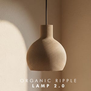 May include: A beige pendant lamp with a textured, dimpled surface and a narrow neck, suspended by a thin black cord. The text "ORGANIC RIPPLE LAMP 2.0" is printed in white at the bottom of the image, centered below the lamp fixture.