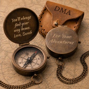 Peut inclure: Deux boussoles en laiton de style ancien avec chaînes. Une boussole est ouverte, révélant un cadran avec les points cardinaux et un couvercle gravé : You'll always find your way home. Love, Sarah. L'autre est fermée, gravée : For Your Adventures.