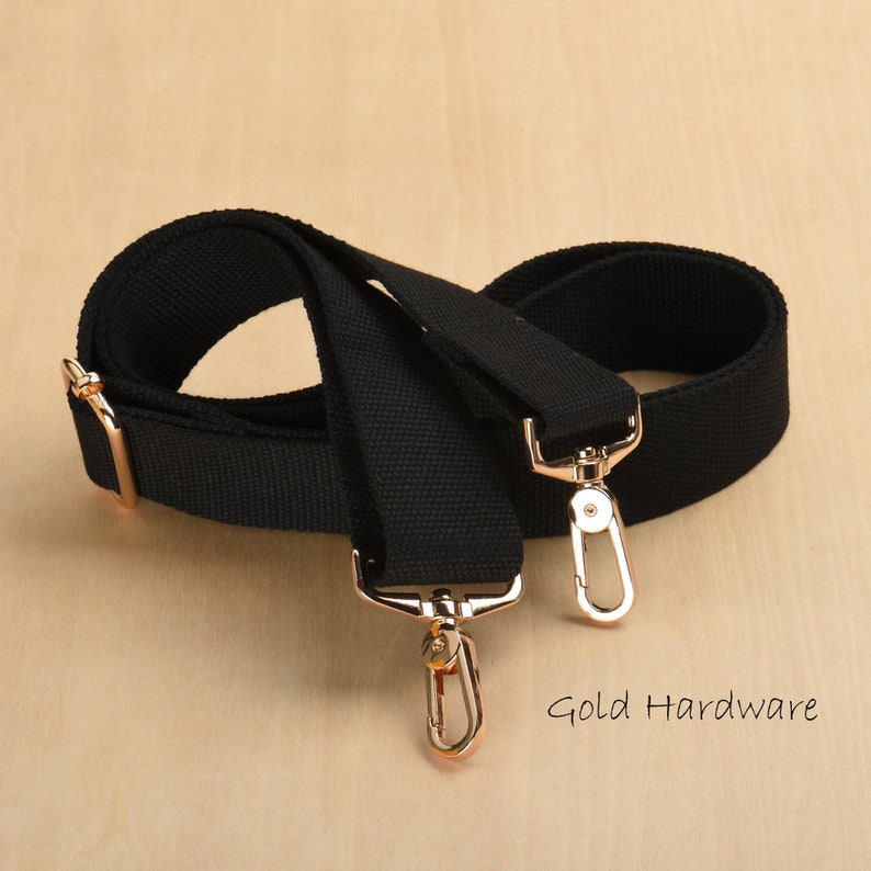 May include: Black canvas adjustable strap with gold hardware and two swivel hooks.  Gold Hardware.