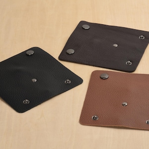 May include: Three leather pouches with snap closures. The pouches are black, brown, and black. The pouches are all the same size and shape.