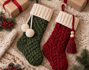 May include: Two knit Christmas stockings with cream-colored ribbed cuffs. One stocking is dark green with a textured stitch and two cream pom-poms. The other is deep red with a cable knit pattern and a matching red tassel with wooden beads.