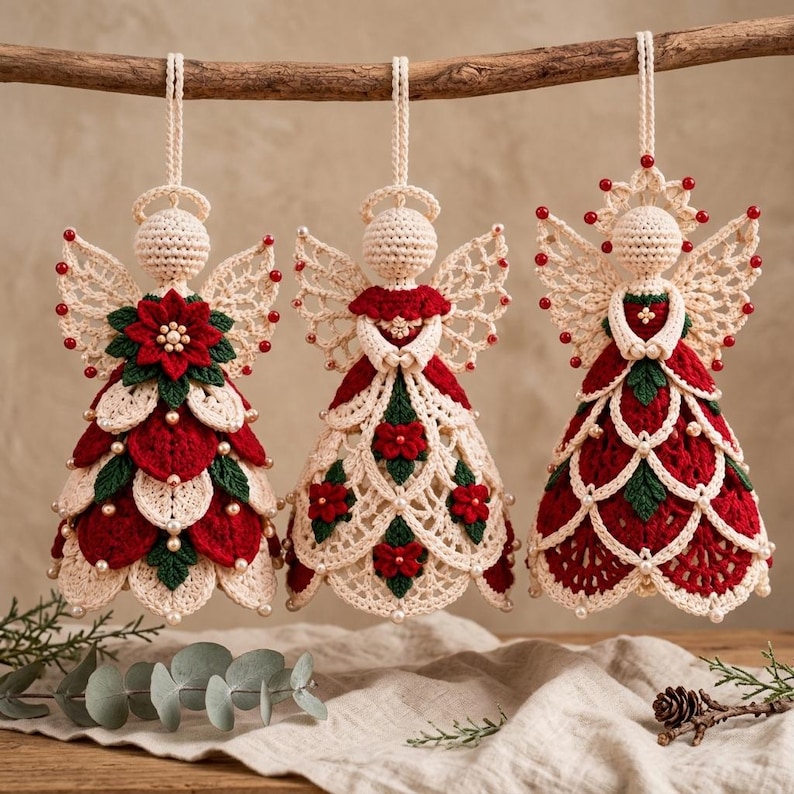 May include: Three crocheted angel ornaments hanging from a wooden branch. Each figure features cream, red, and green yarn with small white beads. The angels have detailed wings, halo accents, and layered skirts decorated with floral motifs.