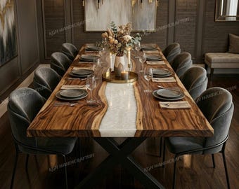 May include: A large, rectangular dining table with a live edge design, featuring a light-colored resin river down the center. The table is surrounded by grey velvet chairs and set with place settings. The table is approximately 305 cm long.
