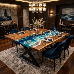 Op de afbeelding: Een grote, rechthoekige eettafel met een houten blad met een levende rand en een blauw en wit hars rivierontwerp. De tafel wordt ondersteund door een zwart metalen onderstel en is omringd door blauwe fluwelen stoelen. De tafel is gedekt voor een formeel diner.