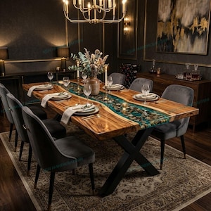 May include: A large, wooden dining table with a river-like design in the center, filled with stones and blue resin. The table is surrounded by gray velvet chairs and set with elegant place settings. A chandelier hangs above.