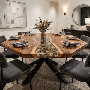 May include: A large octagonal dining table featuring a natural wood grain surface with a central river-like inlay filled with smooth river stones. The table is supported by a black metal base and surrounded by six dark gray upholstered chairs.